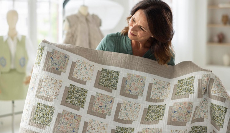 Woman using the EV1 quiltbroidery function to create a quilt 