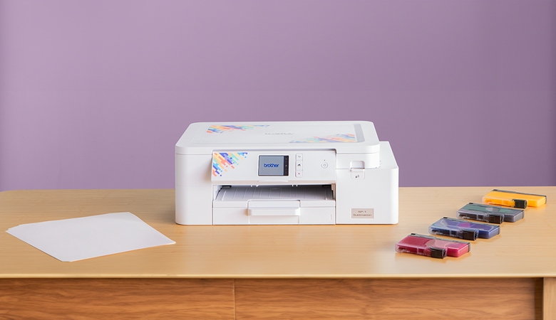 Brother Sublimationsdrucker SP1 auf einem Tisch mit 4 Tintenpatronen und einem Sublimationspapier