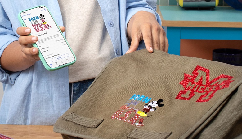 Frau mit Handy und Tasche mit Disney-Vinylmotiven