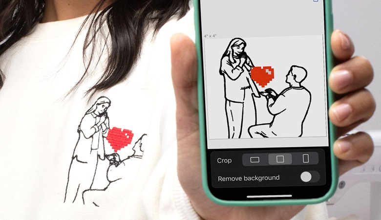 Frau hält Handy mit Artspira-Stickmuster in der Hand