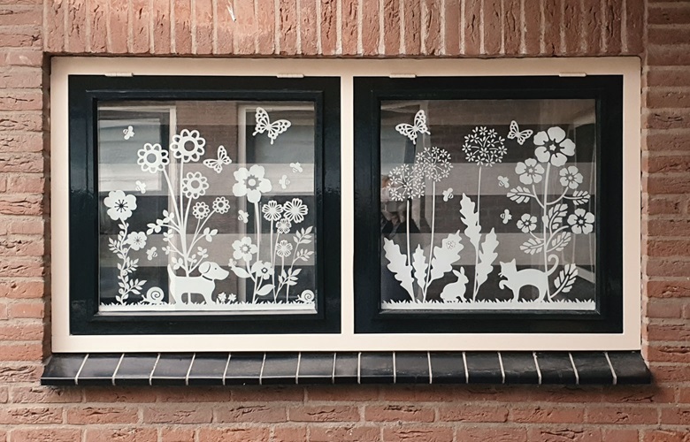 close-up van witte raamstickers van bloemen en dieren