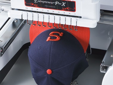 Casquette bleue et rouge dans une machine à broder