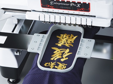 Embroidered golden letters in embroidery frame