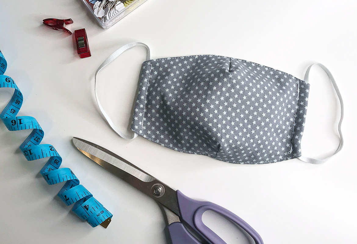Masque en tissu bleu étoilé avec ruban à mesurer et ciseaux