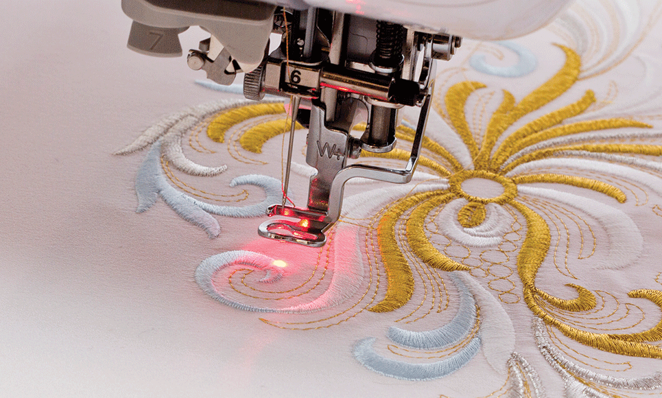 Stickfuß mit LED-Pointer und rotem Punkt auf Stickmuster