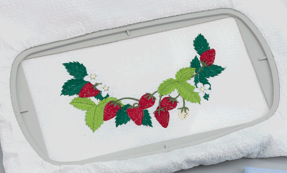 Aardbeipatroon op witte handdoek in borduurraam