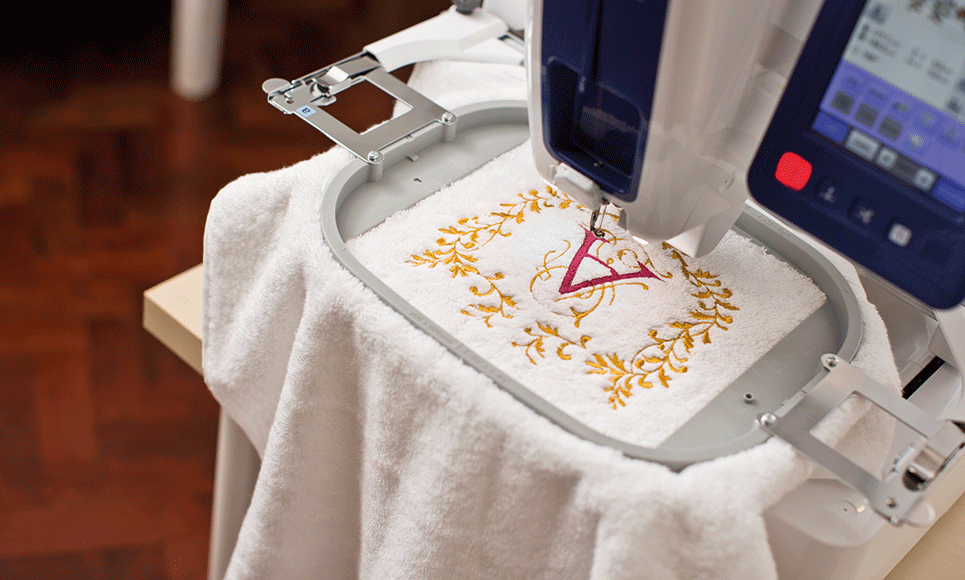 White embroidered towel with large A and frame on VR machine
