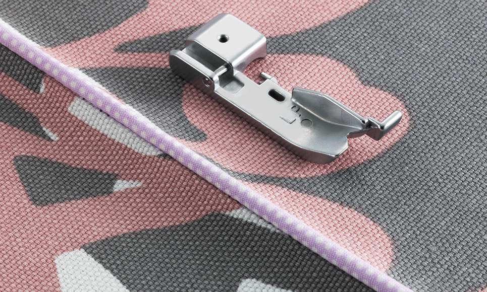 Overlocker piping foot on fabric with lilac piping sewn in fabric edge