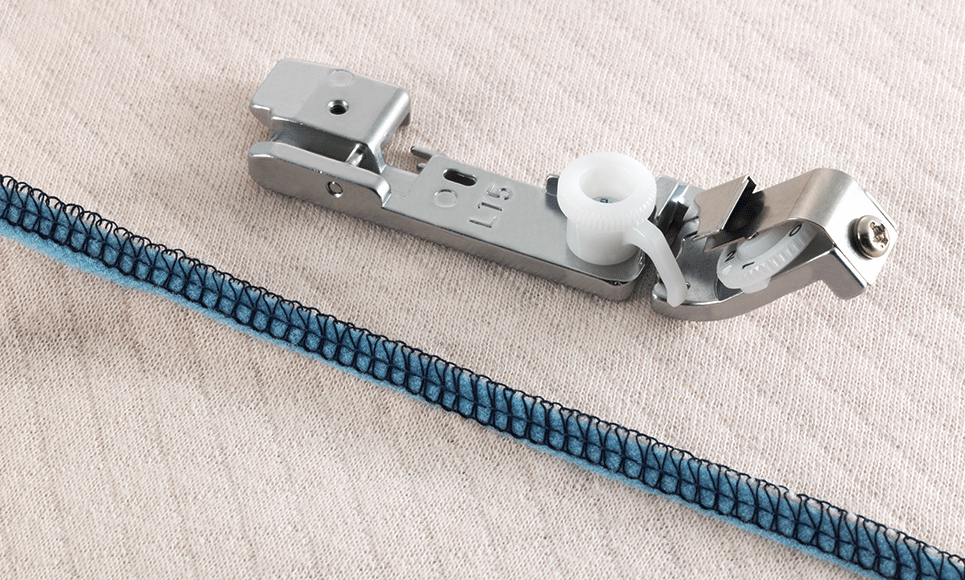 Overlocker taping foot on white fabric with blue sewn tape sample
