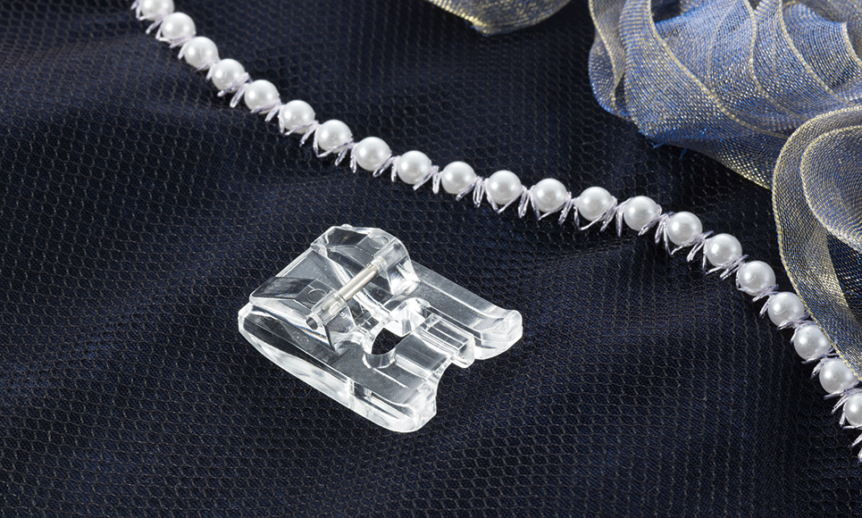 Pied pose-perles en plastique sur tissu sombre avec rangée de perles