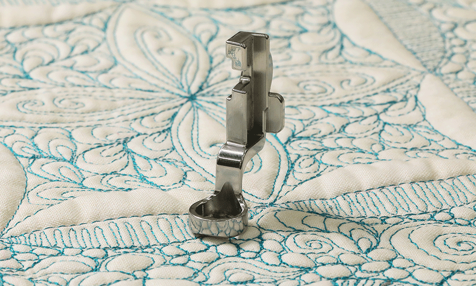 Ruler foot for high shank on white fabric with blue ornate stitching